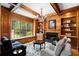 Cozy den with wood paneled walls, beamed ceiling, fireplace, large window seat, and built-in bookshelves at 3639 Paper Mill Se Rd, Marietta, GA 30067