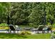 Beautiful backyard pool featuring comfortable patio seating and umbrellas surrounded by professionally landscaped yard at 3639 Paper Mill Se Rd, Marietta, GA 30067