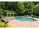 Beautiful backyard pool area with a hot tub, lounge chairs, and lush greenery, perfect for relaxation at 3639 Paper Mill Se Rd, Marietta, GA 30067
