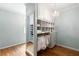 Bright, tidy walk-in closet boasts custom shelves and clothing racks for ample storage at 3639 Paper Mill Se Rd, Marietta, GA 30067