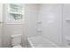 Bathroom featuring a white shower and bath combo, white toilet, and a window at 3729 Meadow Glen Cir, Ellenwood, GA 30294