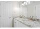 Bathroom with double granite vanity and brushed nickel faucets, white cabinets, and a large mirror at 3729 Meadow Glen Cir, Ellenwood, GA 30294