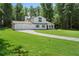 A beautiful two-story home showcases lush green lawn, long driveway and mature trees at 3729 Meadow Glen Cir, Ellenwood, GA 30294