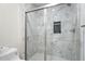 Modern tiled shower with glass doors and built in shower caddy at 3729 Meadow Glen Cir, Ellenwood, GA 30294