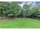 Large, grassy backyard with mature trees and ample space at 5514 E Stoneway Ct, Villa Rica, GA 30180