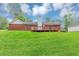 Spacious, grassy backyard with a wood deck and a brick house at 5514 E Stoneway Ct, Villa Rica, GA 30180