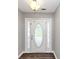 Bright entrance with a decorative glass door and dark laminate flooring at 5514 E Stoneway Ct, Villa Rica, GA 30180