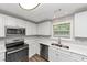 This kitchen features stainless steel appliances, double sinks and white cabinetry at 5514 E Stoneway Ct, Villa Rica, GA 30180
