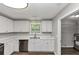 Bright kitchen with white cabinets, stainless steel dishwasher, and laminate floors at 5514 E Stoneway Ct, Villa Rica, GA 30180