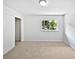 Bright bedroom features neutral carpet, a window with a treed view, and a closet for storage at 1175 Church St # B, Decatur, GA 30030