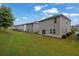 The backyard features a lush green lawn and neighbors houses with grey siding at 1998 Nuthatch Dr, Hoschton, GA 30548