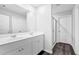 Bright bathroom featuring double vanity, a large mirror, wood floors, and glass shower door at 1998 Nuthatch Dr, Hoschton, GA 30548