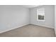 Comfortable bedroom with neutral carpet and a window offering plenty of natural light at 1998 Nuthatch Dr, Hoschton, GA 30548