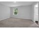 Bright bedroom with neutral paint, plush carpet, and a view of the green outdoors at 1998 Nuthatch Dr, Hoschton, GA 30548