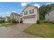 Two-story home featuring a brick facade, two-car garage and driveway, and a well-maintained front yard at 1998 Nuthatch Dr, Hoschton, GA 30548