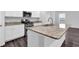 Bright kitchen features a central island with granite countertops and stainless steel appliances at 1998 Nuthatch Dr, Hoschton, GA 30548