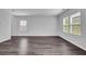 Living room featuring hard wood floors, white walls, and multiple windows for ample natural light at 1998 Nuthatch Dr, Hoschton, GA 30548
