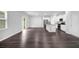 Bright, open-concept living space featuring dark wood floors, an island kitchen, and large windows at 1998 Nuthatch Dr, Hoschton, GA 30548