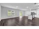 Bright, open-concept living space with dark wood floors, an island kitchen, and sliding glass doors at 1998 Nuthatch Dr, Hoschton, GA 30548