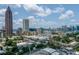 Urban aerial view with city skyline, apartments, and a tree line at 220 Renaissance Ne Pkwy # 1105, Atlanta, GA 30308