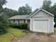 Charming single-story home featuring a garage, complemented by mature trees and partial landscaping at 2850 Cedar Trace Dr, Ellenwood, GA 30294