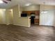 Open concept living space featuring hardwood floors flowing into the kitchen with black appliances and vaulted ceilings at 2850 Cedar Trace Dr, Ellenwood, GA 30294