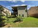 This home features a backyard with a 2 level porch, green grass, and large green plants at 3020 Whitfield Ave, Cumming, GA 30040