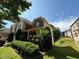 A view of the house with beautiful landscaping on a sunny day and a cloudy blue sky at 3020 Whitfield Ave, Cumming, GA 30040