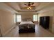 Spacious main bedroom featuring a tray ceiling, ceiling fan, and abundant natural light at 3020 Whitfield Ave, Cumming, GA 30040