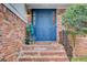 A close up of a blue front door featuring brickwork, iron railing, and greenery, enhancing its appeal at 2270 Old Concord Se Dr, Covington, GA 30016