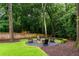 Serene backyard with a fire pit and Adirondack chairs surrounded by lush landscaping and trees at 281 Green Hill Rd, Atlanta, GA 30342