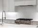 Close-up of kitchen featuring stainless steel stove, quartz countertop, and white subway tile backsplash at 281 Green Hill Rd, Atlanta, GA 30342