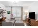 Cozy living room featuring a modern gray sofa, stylish shelving, and a media cabinet with hardwood floors at 281 Green Hill Rd, Atlanta, GA 30342