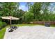 Backyard patio with lounge chairs, an umbrella, and well-manicured lawn surrounded by lush greenery at 281 Green Hill Rd, Atlanta, GA 30342