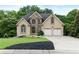 Elegant two-story home featuring a stone facade, well-manicured lawn, and a spacious two-car garage at 2314 Tall Timbers Ln, Marietta, GA 30066