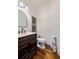 Elegant half bathroom featuring dark wood vanity, framed mirror, and hardwood floors at 2314 Tall Timbers Ln, Marietta, GA 30066