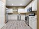 Bright kitchen with stainless steel appliances, white cabinets, and wood-look flooring at 2314 Tall Timbers Ln, Marietta, GA 30066