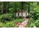 Charming storage shed nestled in a private backyard garden, surrounded by lush greenery and a stone path at 2314 Tall Timbers Ln, Marietta, GA 30066
