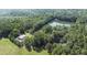 Aerial view of property, highlighting home and surrounding pond nestled in mature trees at 2371 Leguin Mill Rd, Locust Grove, GA 30248