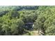 Aerial view of home surrounded by trees and featuring access to a pond at 2371 Leguin Mill Rd, Locust Grove, GA 30248