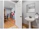 Powder room off of living area with hardwood floors and vanity with a pedestal sink at 2371 Leguin Mill Rd, Locust Grove, GA 30248