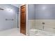 Bright bathroom featuring a tub with shower and glass enclosed shower at 2371 Leguin Mill Rd, Locust Grove, GA 30248