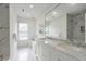 Modern bathroom with double vanity, marble countertops, and stylish marble and glass enclosed shower at 4865 Chesterfield Ct, Suwanee, GA 30024