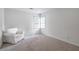 Cozy bedroom with a neutral carpet, natural light, and a comfortable white armchair at 4865 Chesterfield Ct, Suwanee, GA 30024