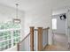 Upstairs hallway featuring a decorative light fixture, window, and view into a carpeted bedroom at 4865 Chesterfield Ct, Suwanee, GA 30024