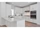 Modern white kitchen with stainless appliances, stone counters, and ample storage at 4865 Chesterfield Ct, Suwanee, GA 30024