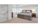 Main bedroom with large bed, two bedside tables and lamps, and view into the en suite bathroom at 4865 Chesterfield Ct, Suwanee, GA 30024
