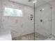 Shower with marble-look tile, a window, and a gray mosaic-look floor at 4865 Chesterfield Ct, Suwanee, GA 30024