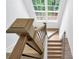 Bright stairway with a window, natural wood banister and treads, and dark metal railings at 4865 Chesterfield Ct, Suwanee, GA 30024