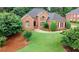 Inviting brick home with mature trees, lush lawn, and meticulously manicured landscape at 8108 Greens Mill Way, Loganville, GA 30052
